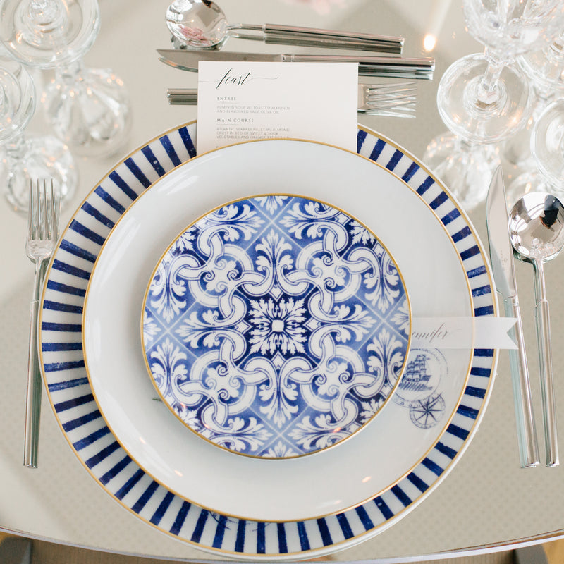 Exquisite dinnerware set with blue patterns and gold rim.